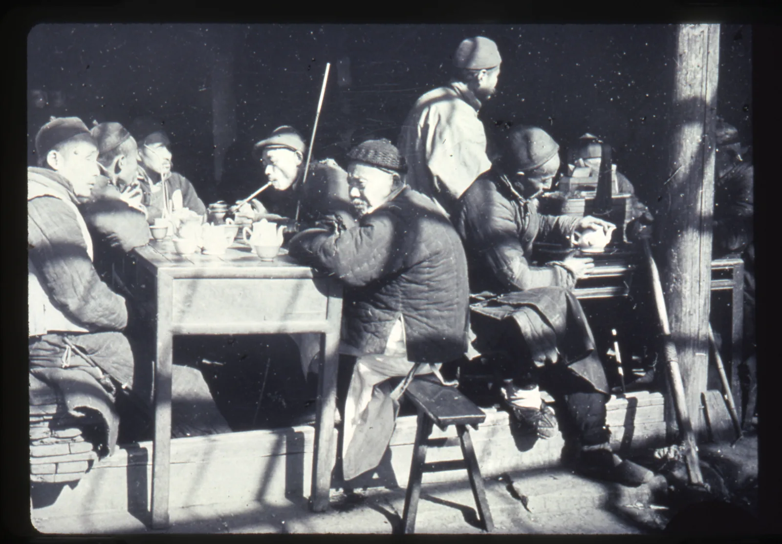 Historical photograph of customers drinking tea in an open-front teashop in Changde, Hunan, China