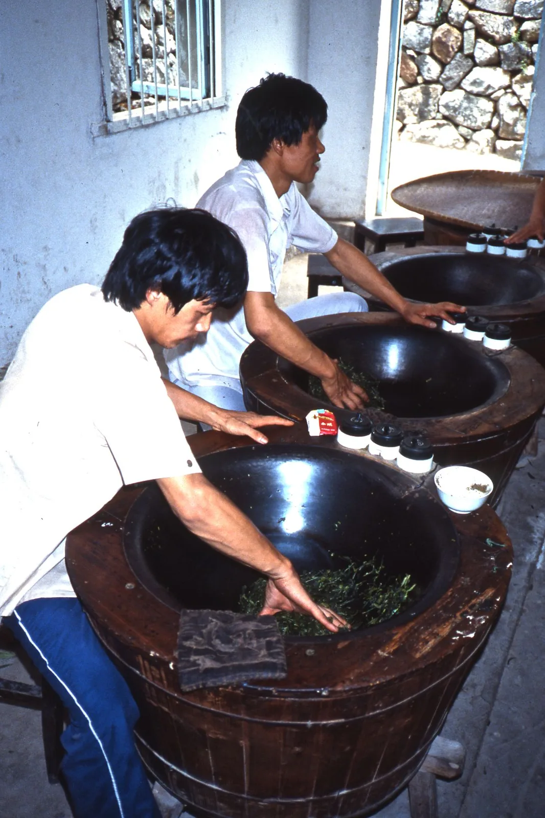 1987 photograph of workers heating tea leaves during a demonstration at a tea plantation in China