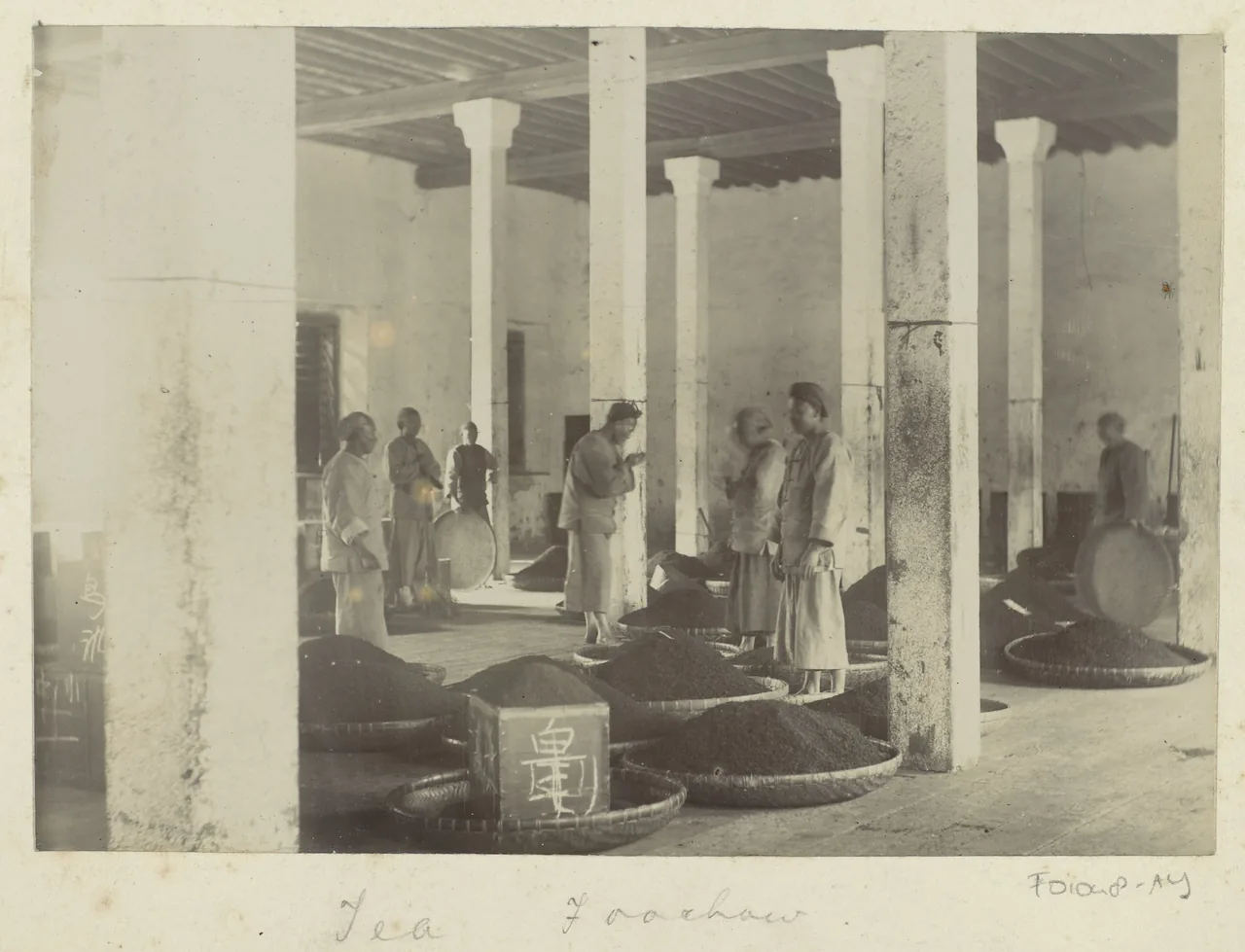 Historical photograph of workers with baskets of tea inside a factory in Fuzhou, China